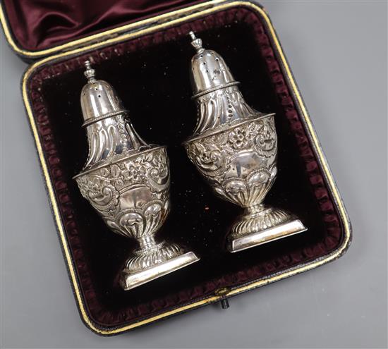 A cased pair of late Victorian silver pedestal pepperettes, London, 1898/9, 10cm.